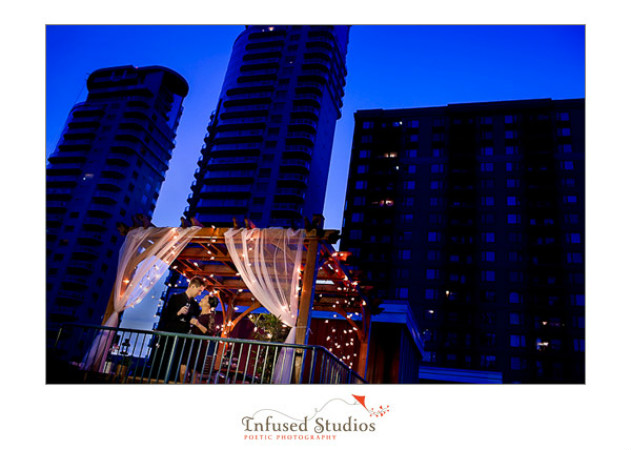 Rooftop gazebo against night skyline :: Engagement photos by infusedstudios.ca
