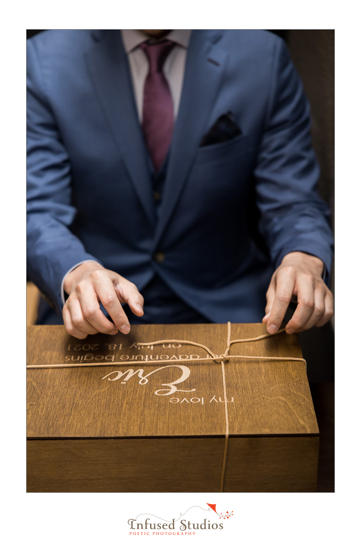 Groom receiving a present from his bride by Calgary wedding photography by Infused Studios