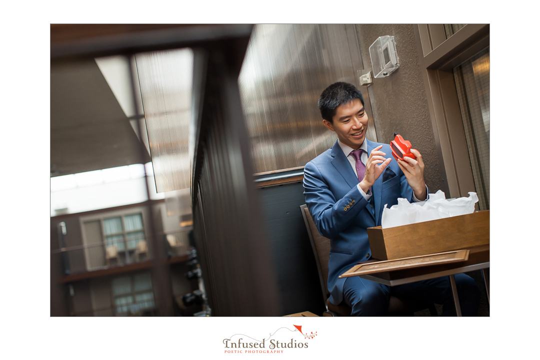 Groom going through present by Calgary wedding photography by Infused Studios