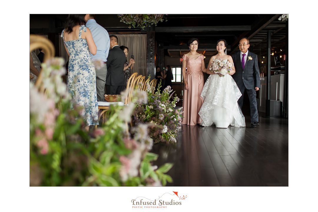 Bride entering with parents by Calgary wedding photographers Infused Studios