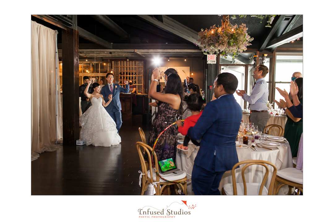 Bride & groom enter wedding reception by Calgary wedding photographers Infused Studios