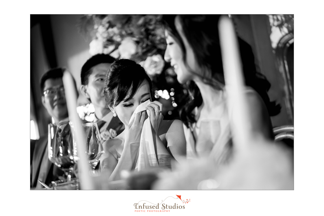 Wiping away tears during wedding speeches by Calgary wedding photographers Infused Studios